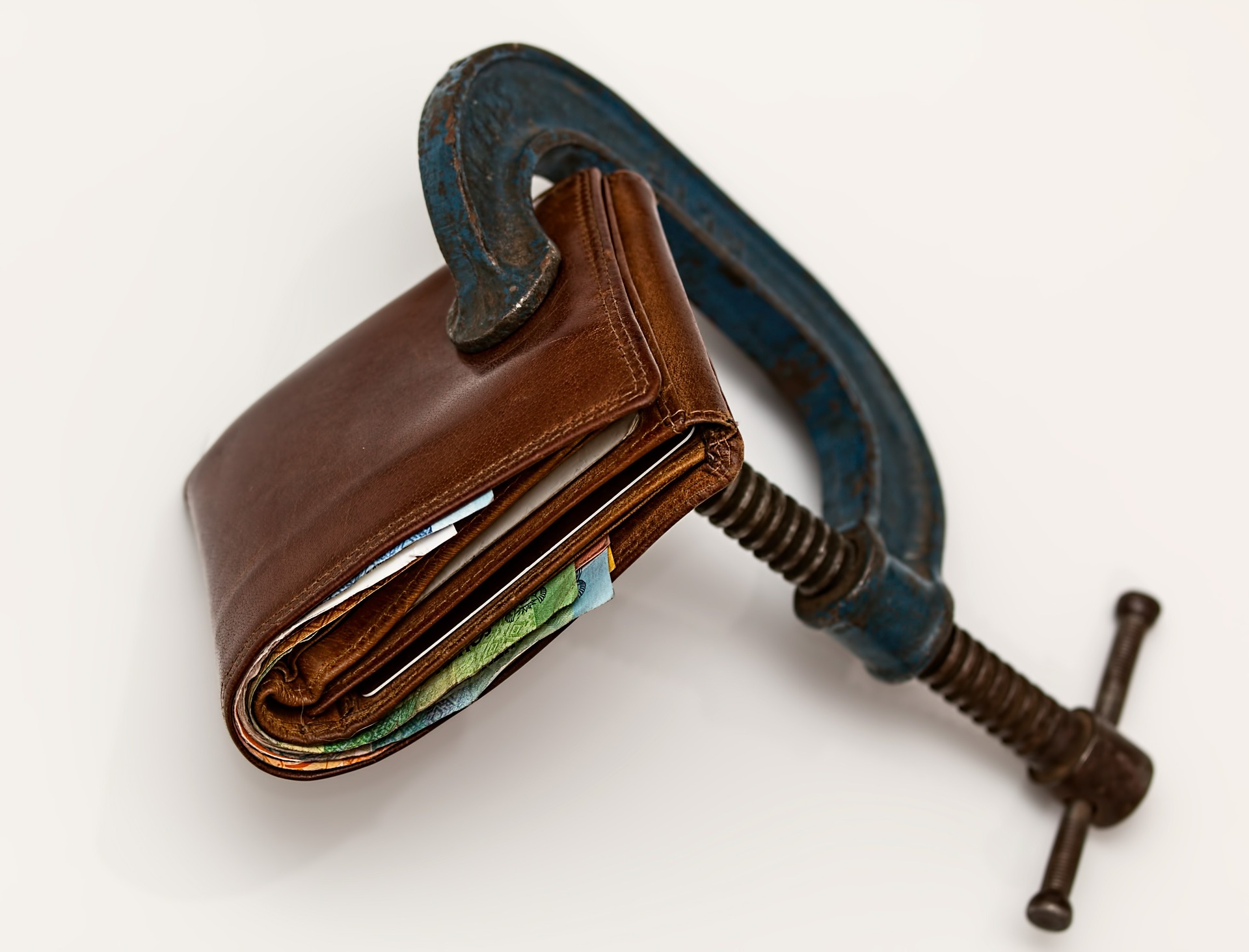 brown wallet with and old clamp on it that is holding it closed