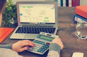 women working calculator and laptop at desk