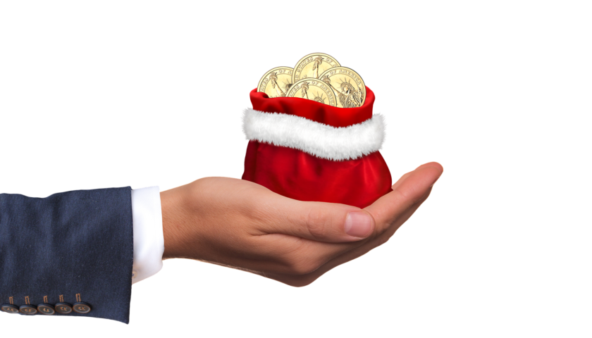 Hand holding a red Santa bag with coins in it