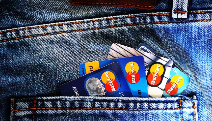 Up close view of a back pocket jeans with four credit cards sticking out