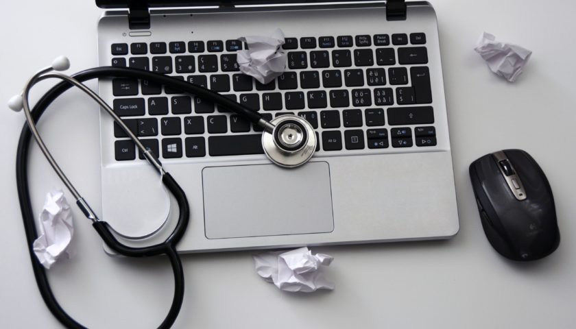 stethescope on laptop with balls of paper thrown on desk