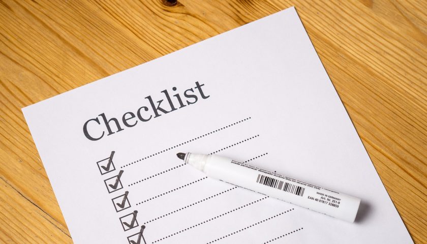 Checklist with check marks going down left side and marker resting on top of list