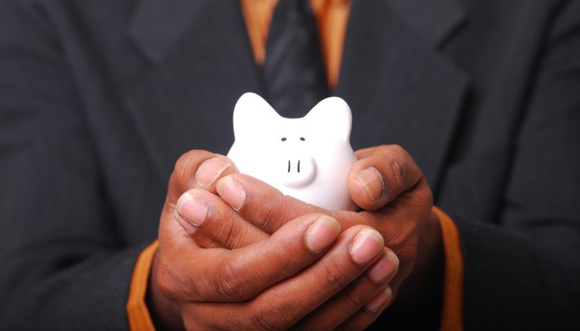 person in suit holding a piggy bank