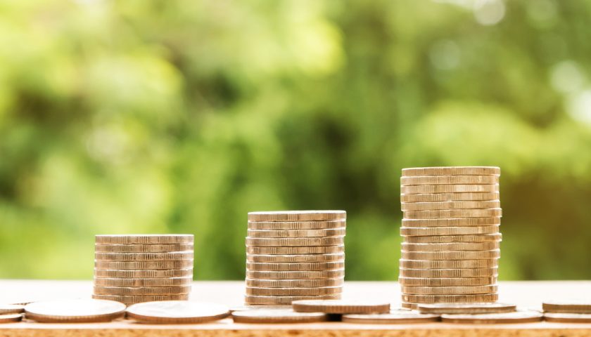 three stacks of coins with green background