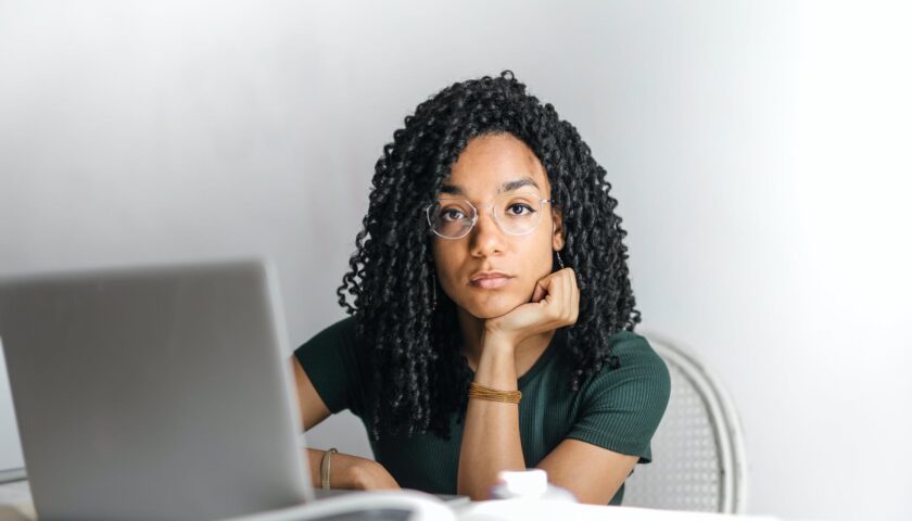 serious ethnic young woman using laptop at home