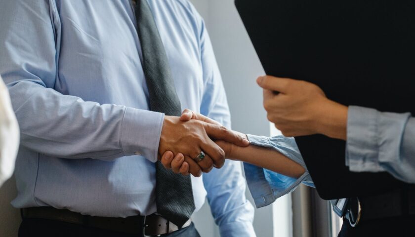 man and woman shaking hands in office