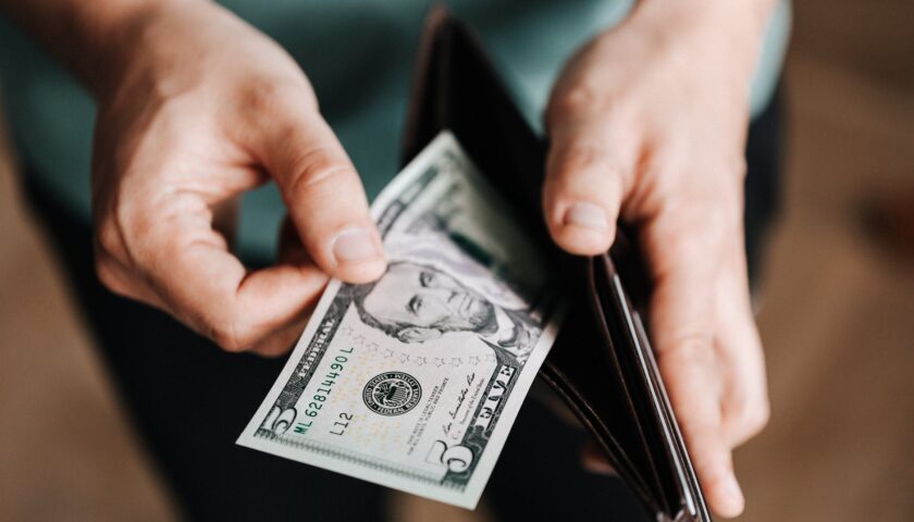 unrecognizable man holding wallet with money