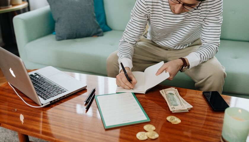 man writing on a notebook